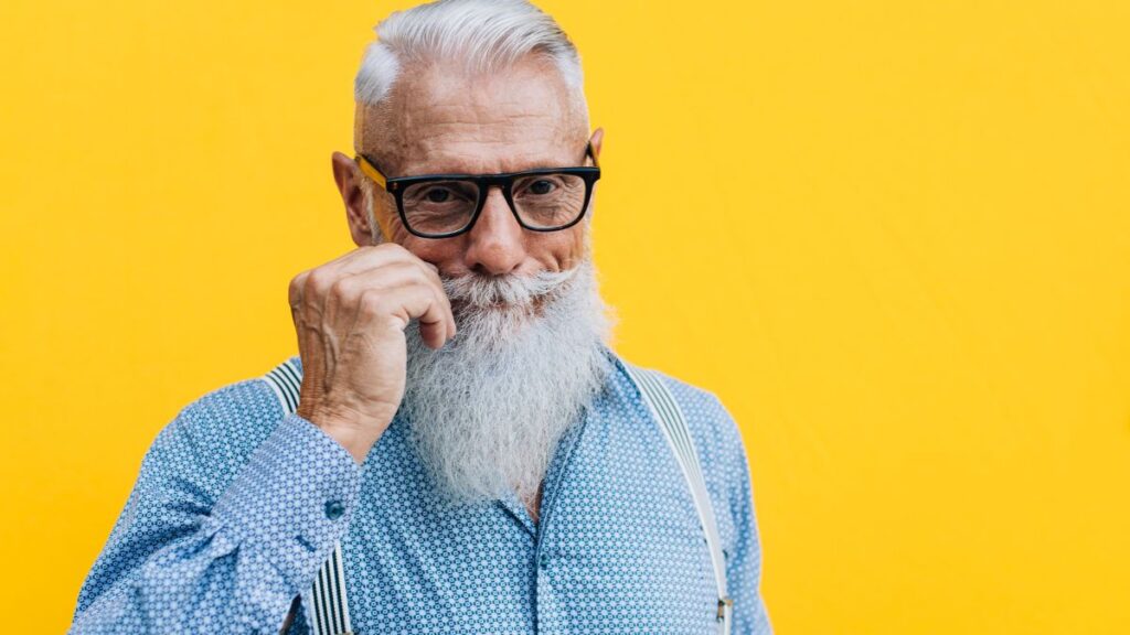 older man twirling his mustache smiling