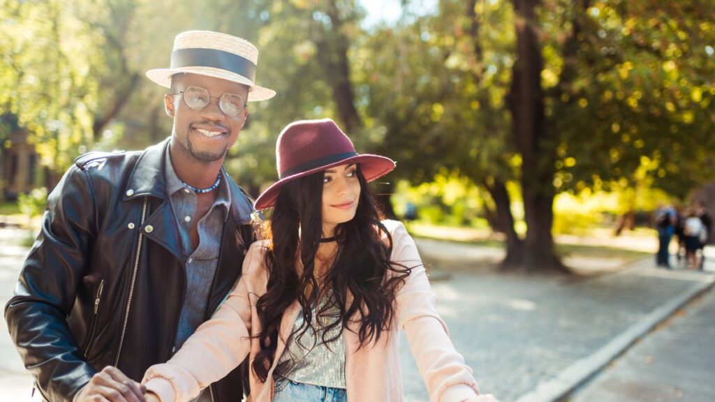 man and woman standing together and holding hands in a park