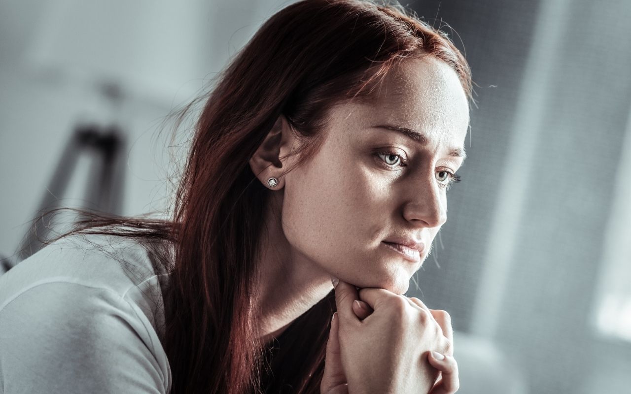 sad woman staring with her head on her chin