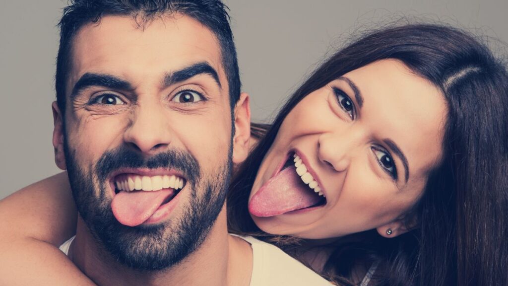 Sense of Humor couple smiling and sticking tongs out happily.