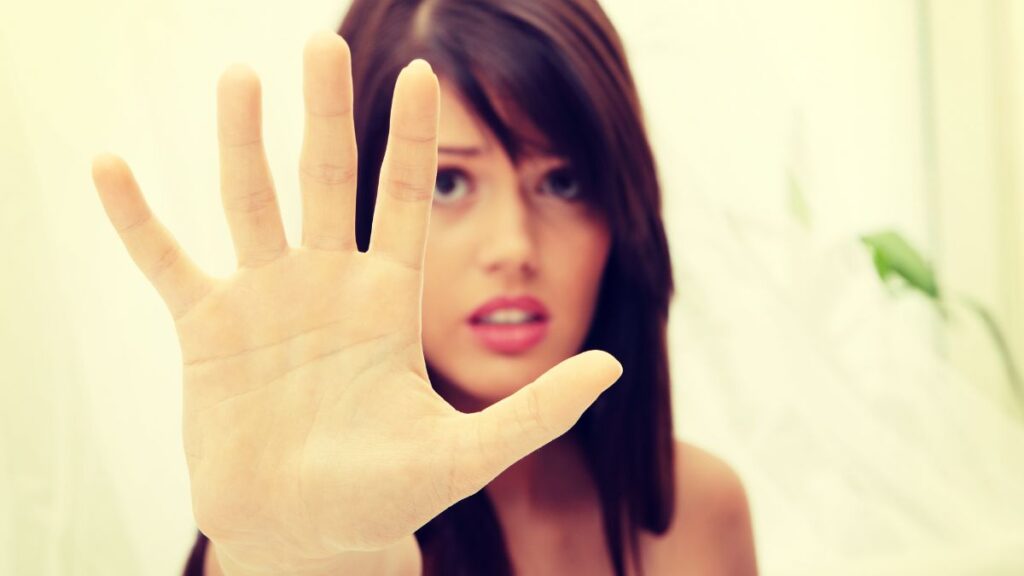 Sexist woman with her hand up looking concerned.