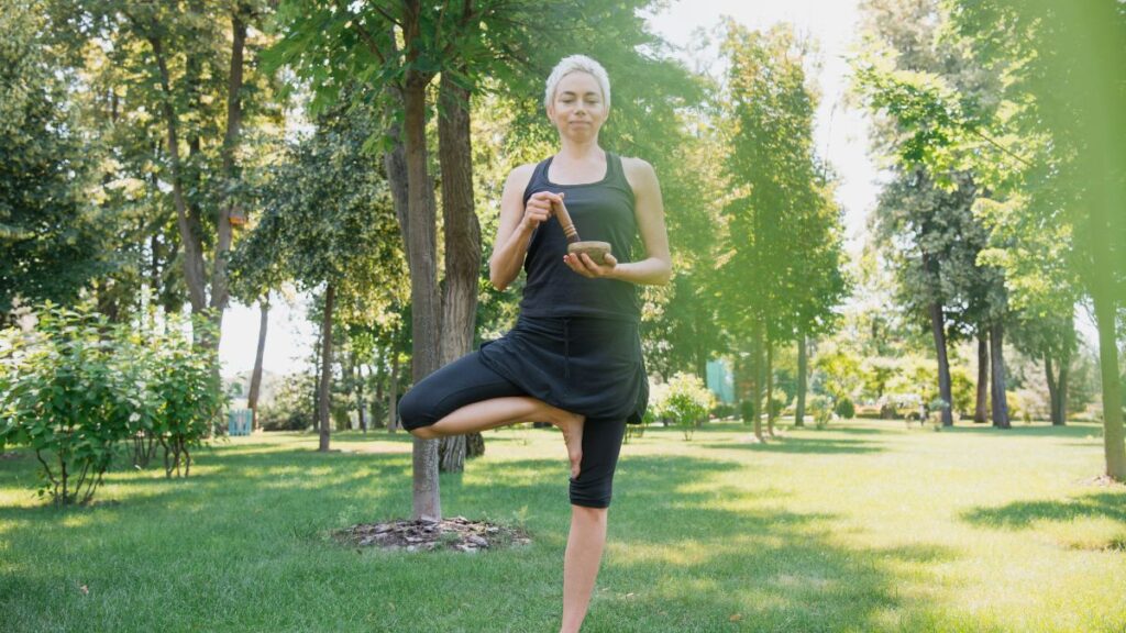 Standing Positions woman standing in tree pose at the park