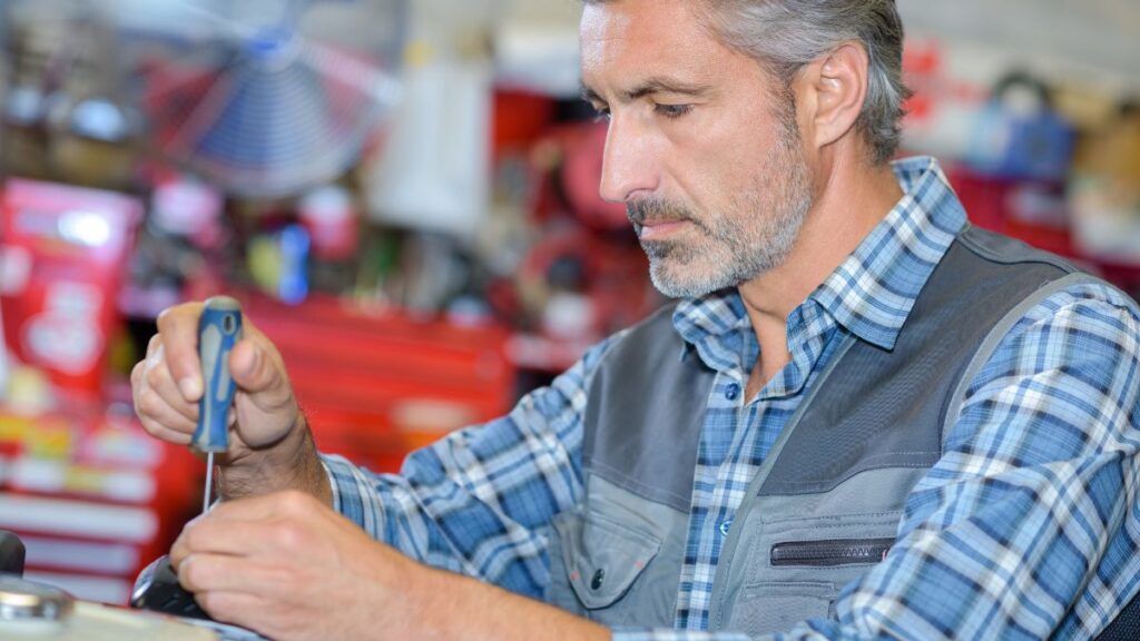 Tool Checks man using screwdriver in a garage