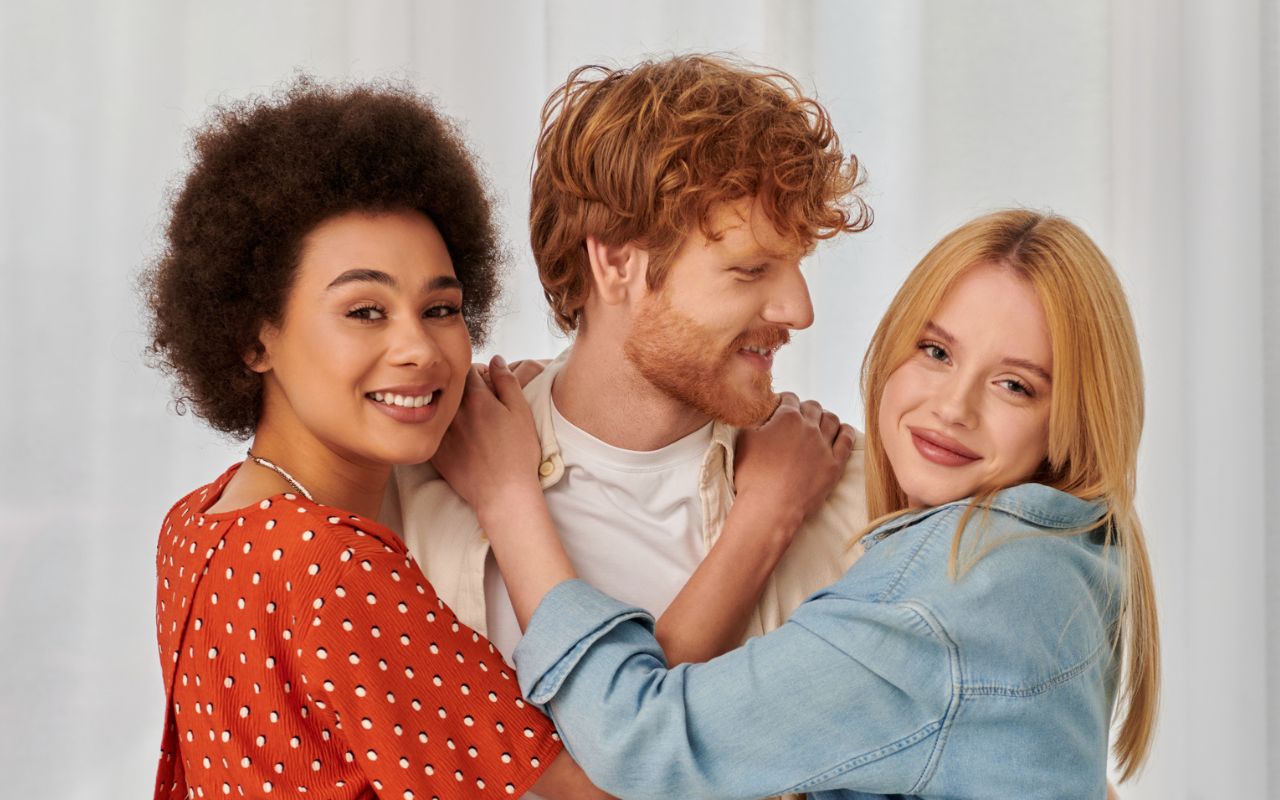 Two women and a man hugging