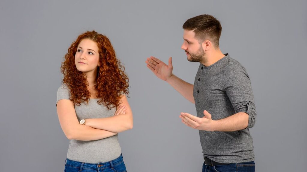 upset couple man talking and woman looking away arms crossed