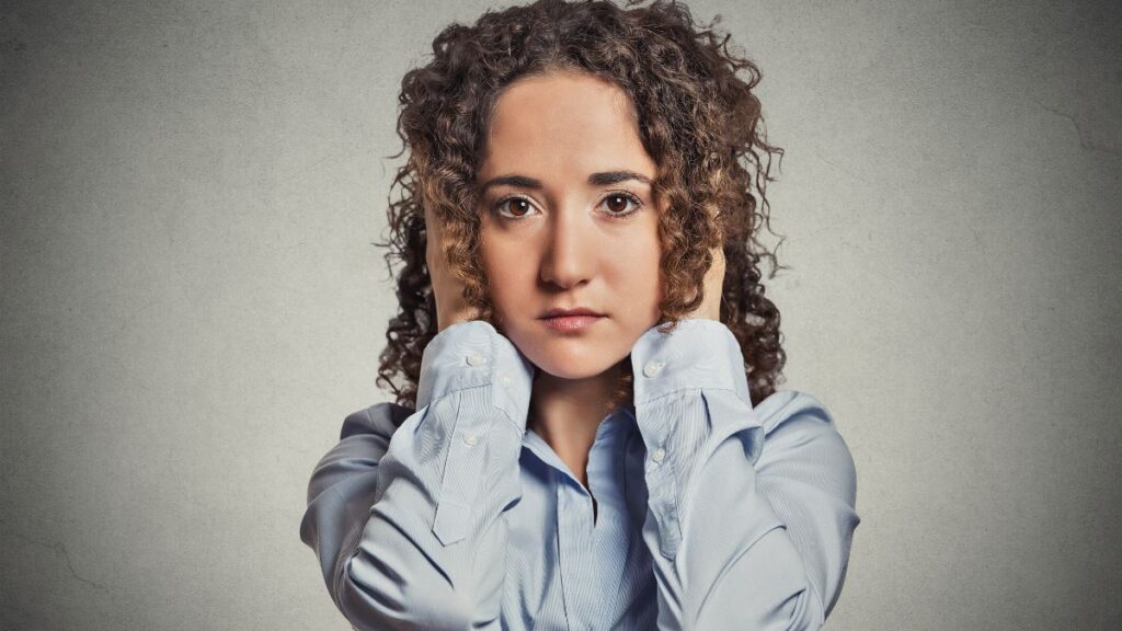 upset woman covering her ears