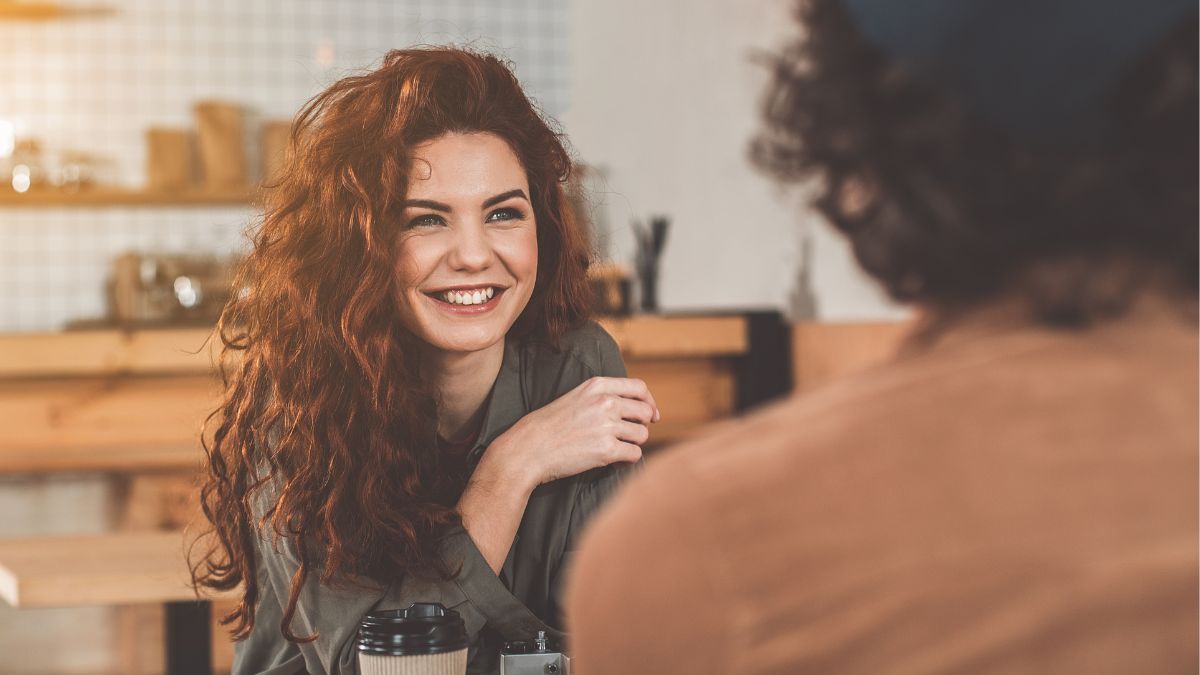 woman at home smiling holding a coffee cup