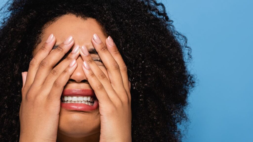 Woman crying while hiding her face with her hands