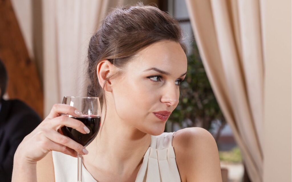 woman holding a glass of wine unhappy