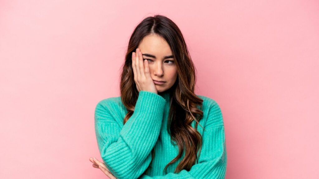 Woman holding her cheek looking dissapointed