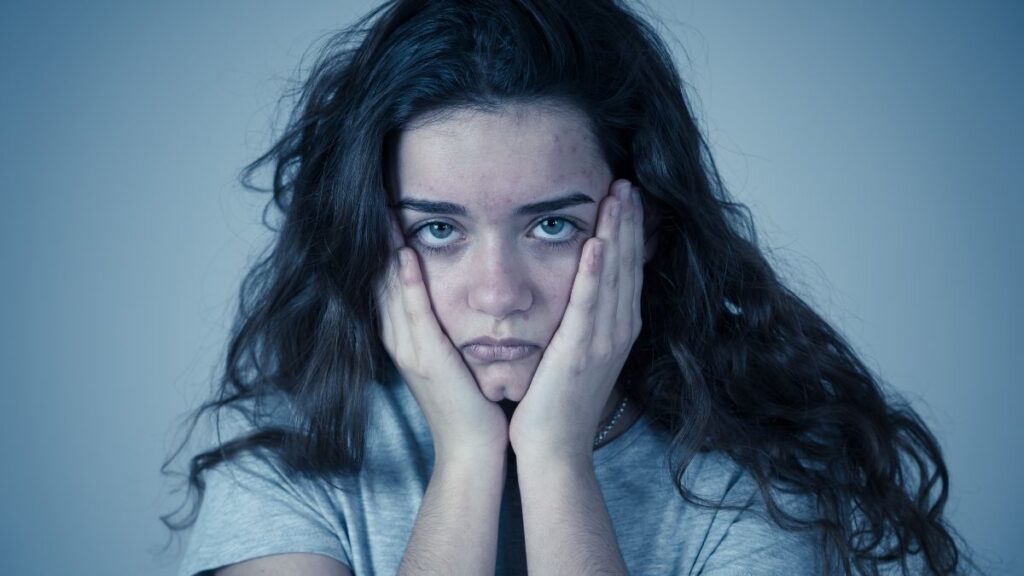 woman holding her face looking stressed and upset