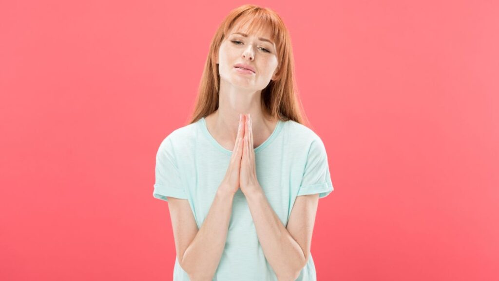 Woman holding her hands like she's praying