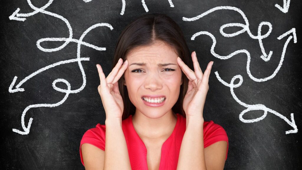 woman holding her head looking confused