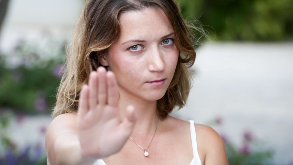 woman holds up hand to show stop