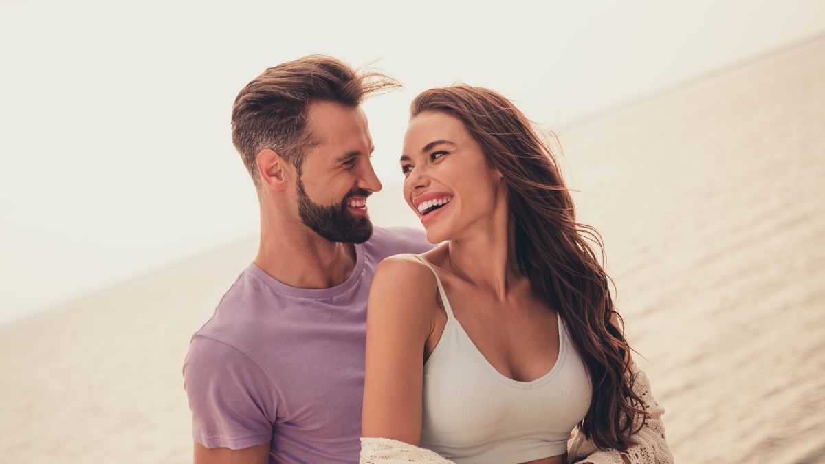 woman looking at her man happily at the beach 