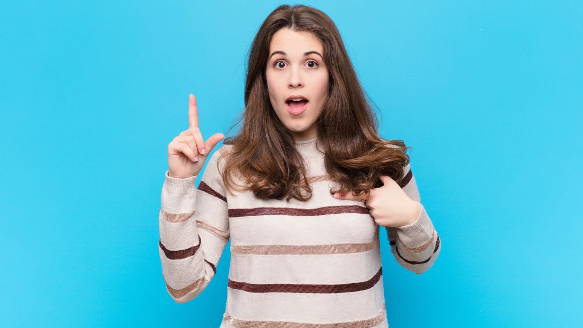 Woman looking confused pointing at herself