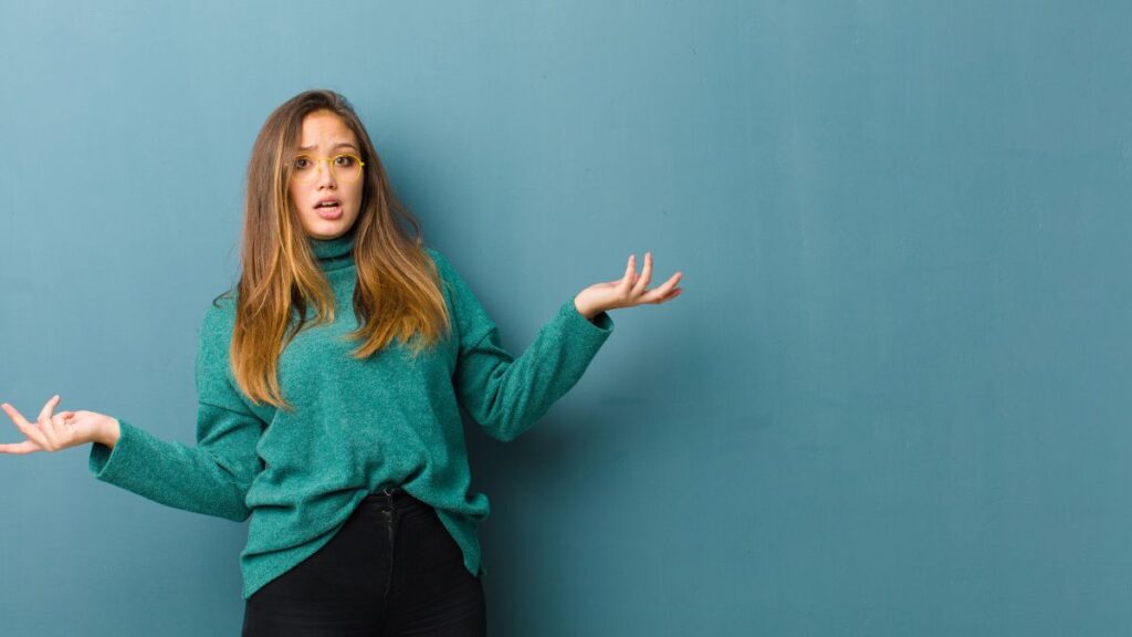 woman looking confused with her hands up