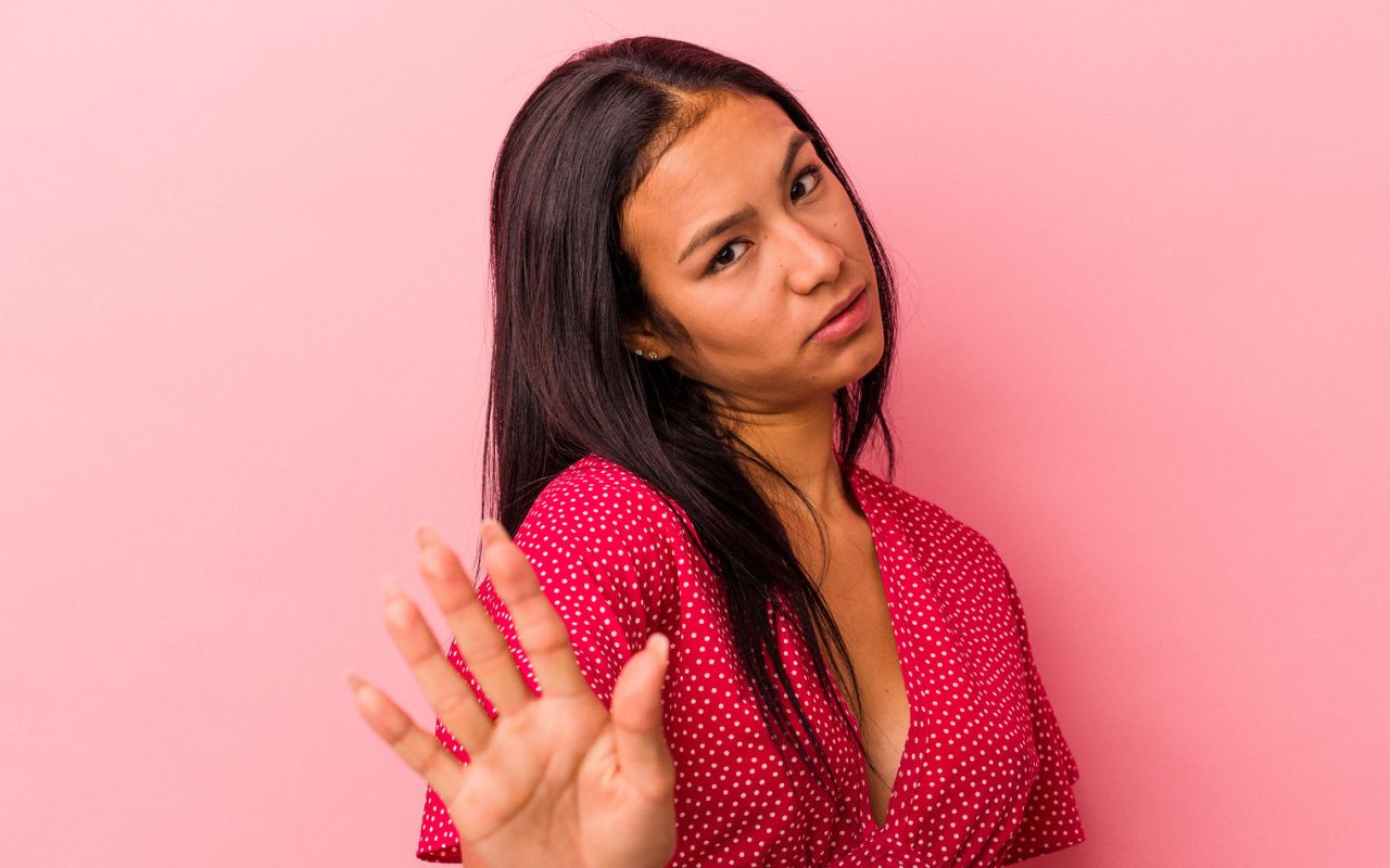 woman looking disappointed with her hand up saying no