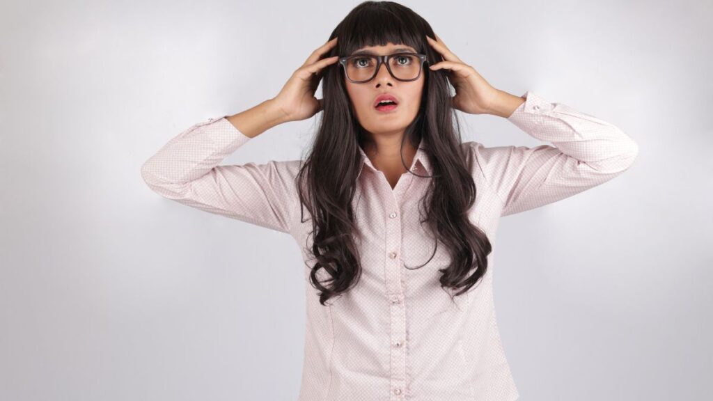 woman looking frustrated with her hands on her head