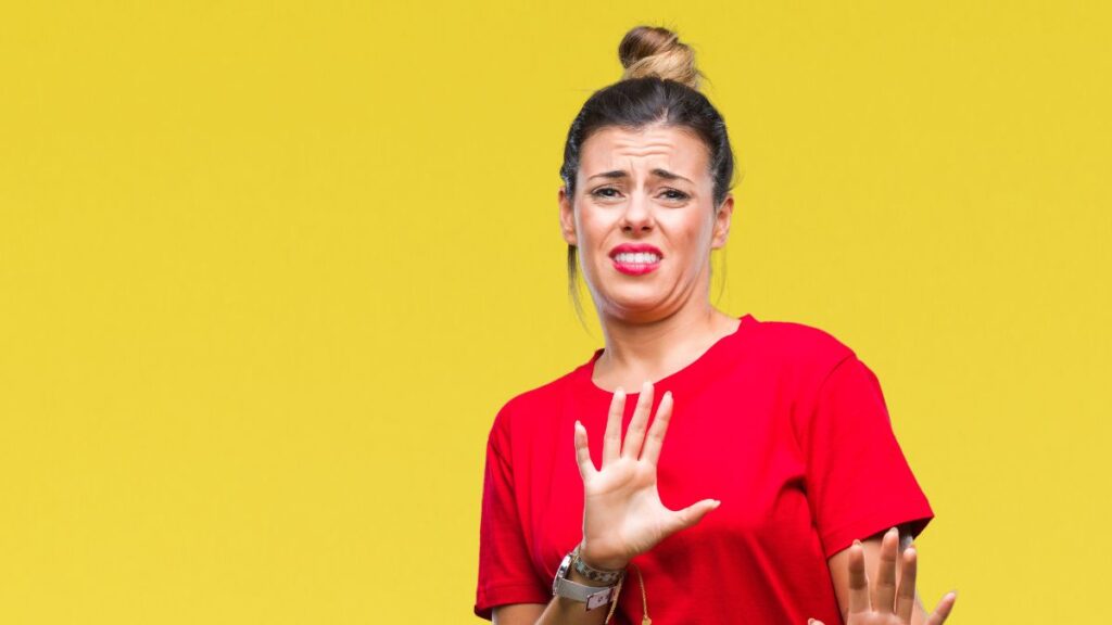 Woman looking grossed out wearing red shirt and lip stick