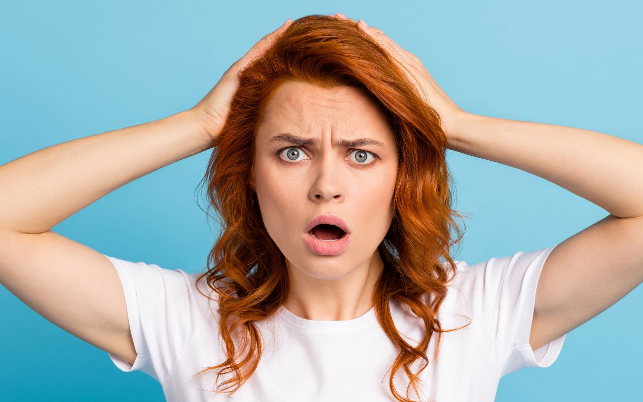 woman looking mad and hands on her head