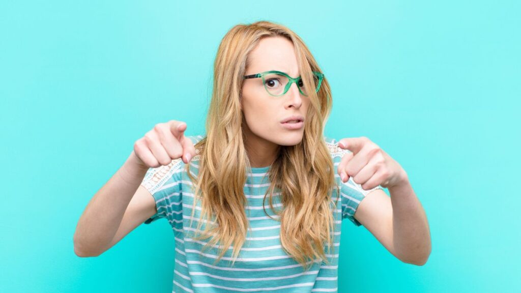 Woman looking serious pointing at the screen as if she was asking us