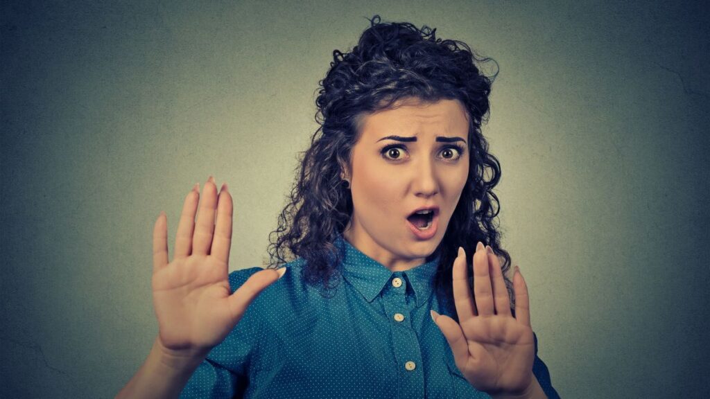 woman looking surprised and upset with hands up