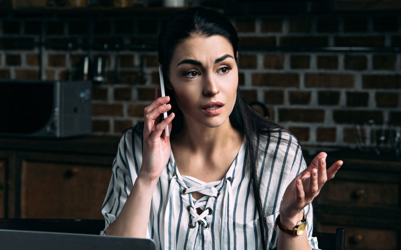 woman looking surprised and worried on the phone