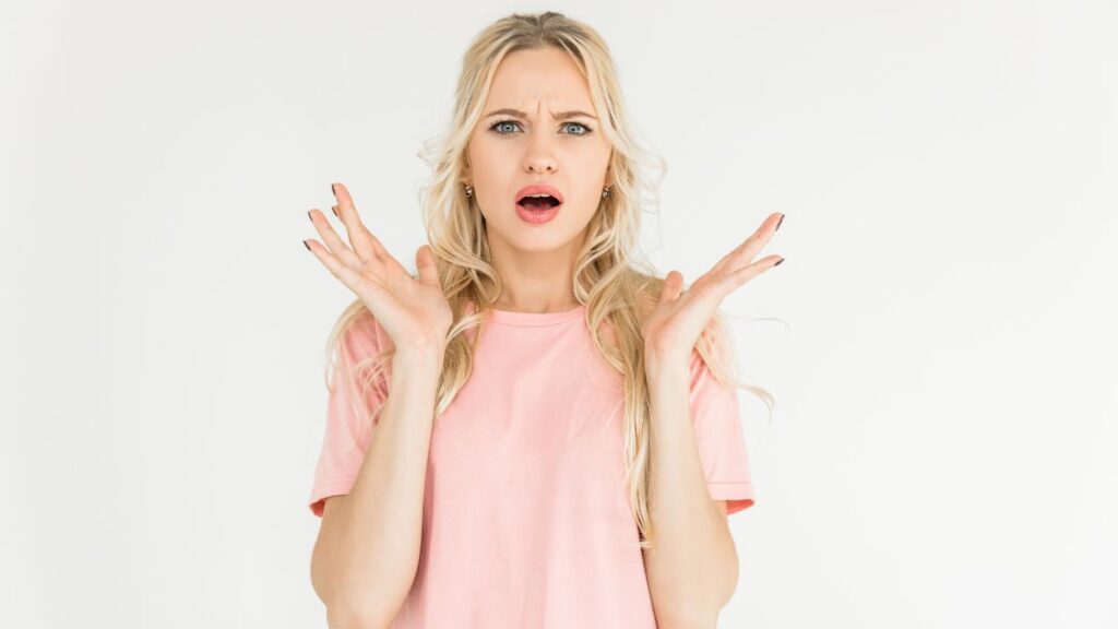 Woman looking surprised with arms out to the side in question