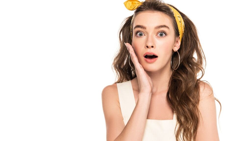 woman looking surprised with hand on face and yellow headband