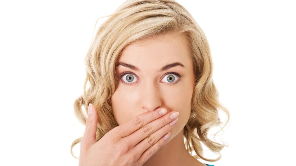 woman looking surprised with hand over his mouth showing oops