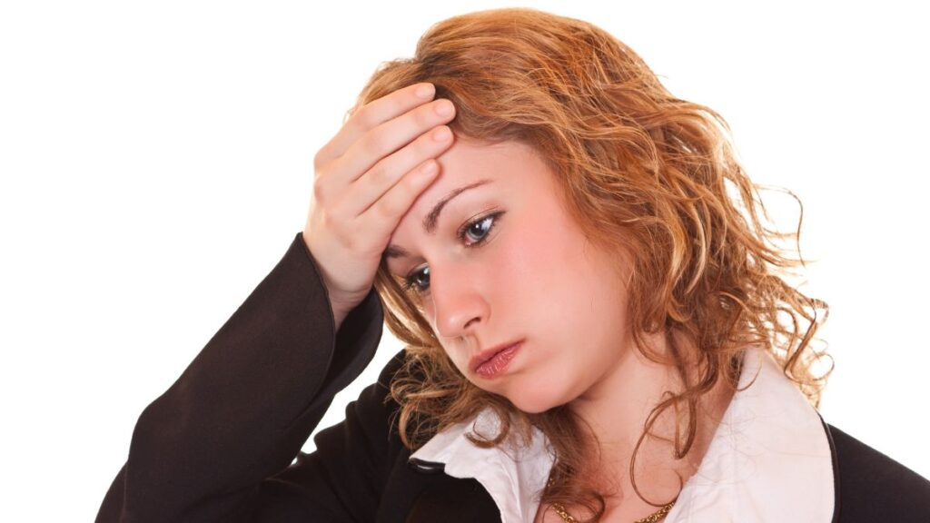 woman looking upset and stressed with her hand on her head