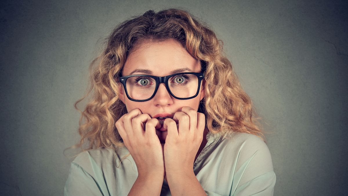 woman looking worried, bitting her nails -