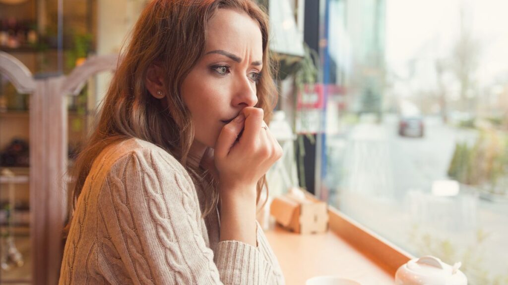 woman looking out the window upset