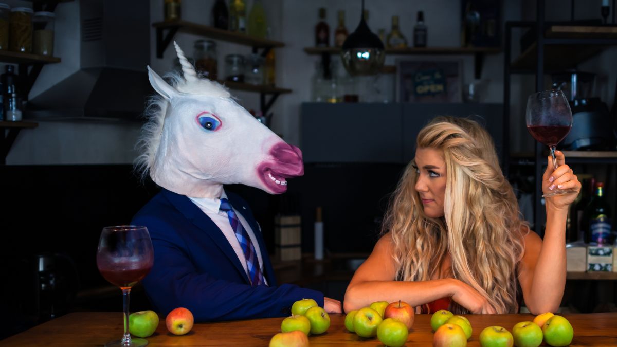 Woman on a date sitting next to a man wearing a horse mask