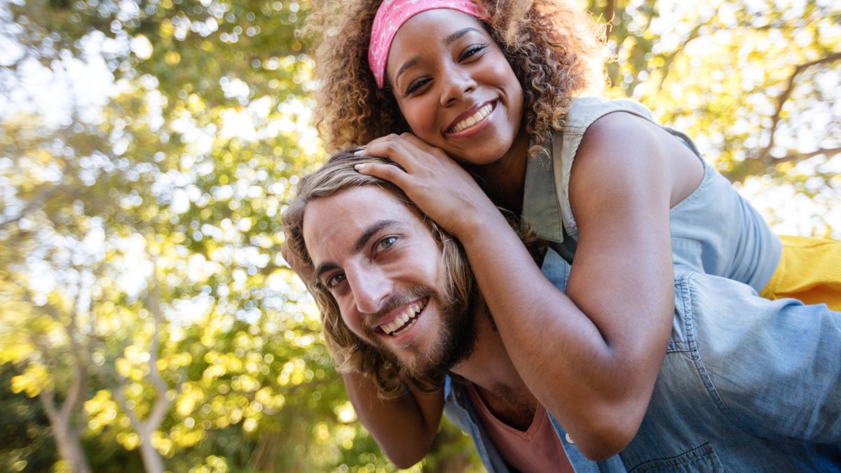 woman on mans back both smiling