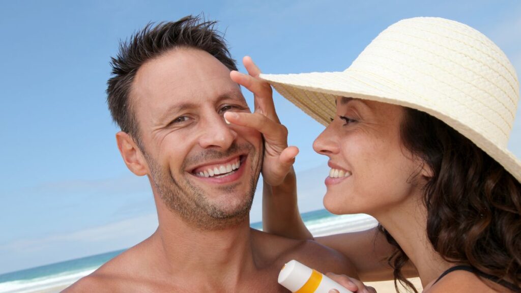 Woman putting sunscreen on a man's face 