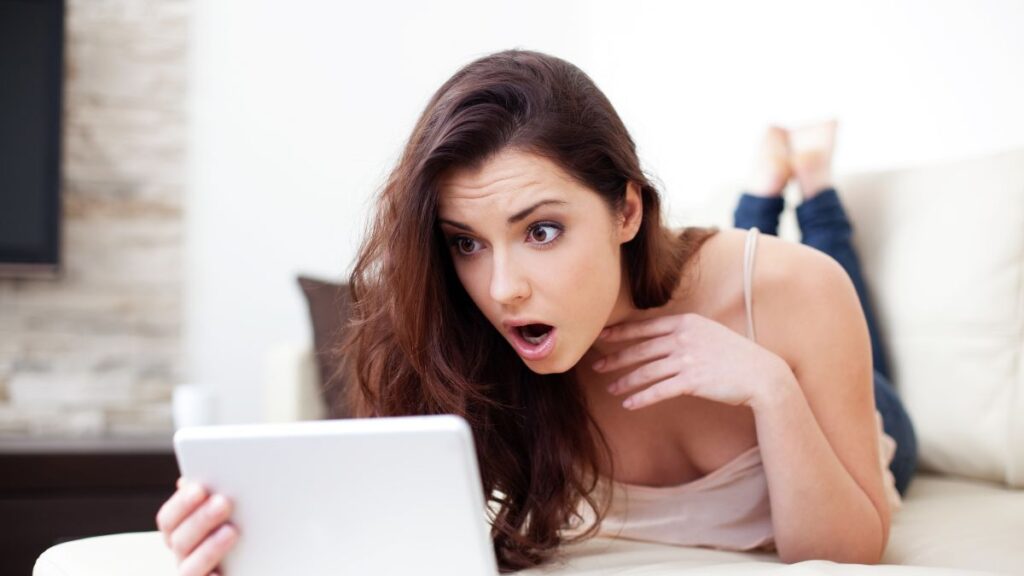 woman looking at a tablet shocked