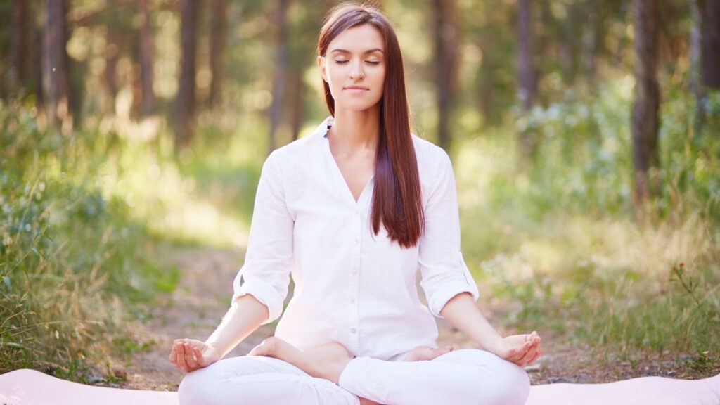 woman sitting in the woods meditating