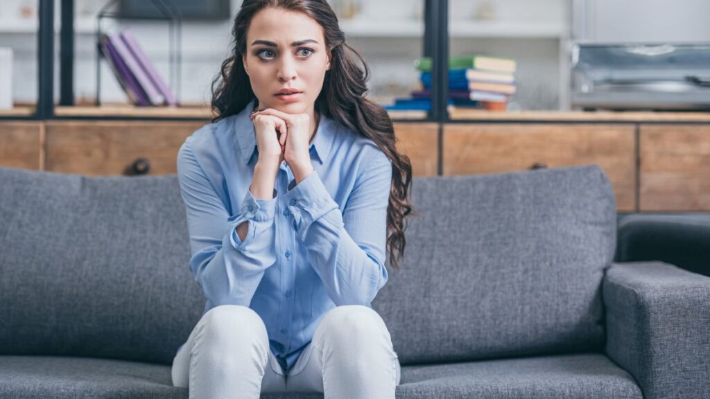 woman sitting on a couch looking nervous