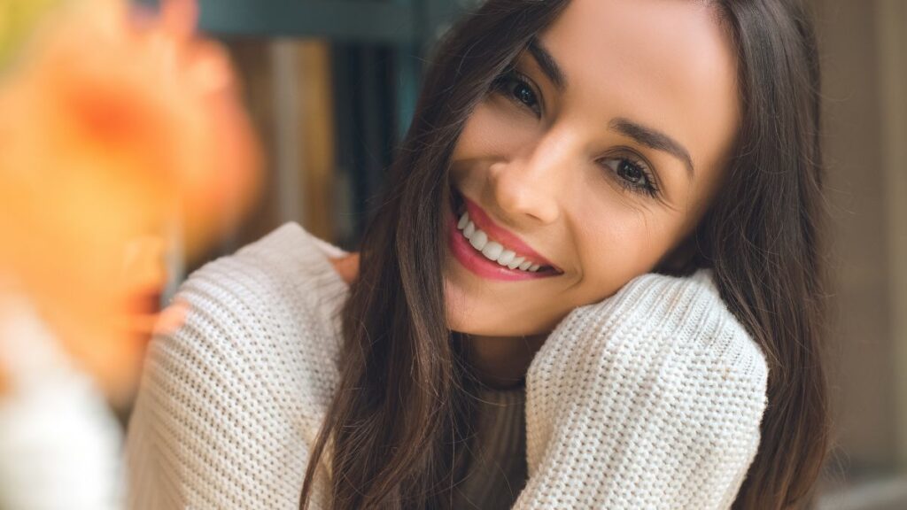 woman smiling with red lipstick and straight brown hair