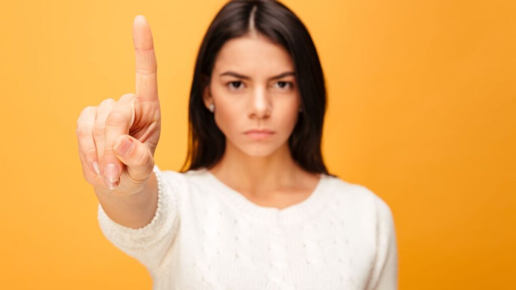 woman standing with her finger up looking serious