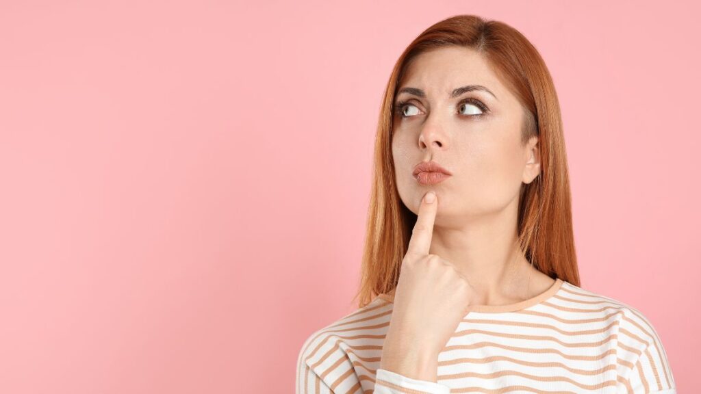 woman thinking with finger on your chin looking away