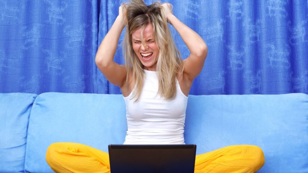 woman upset and pulling out hair at the computer