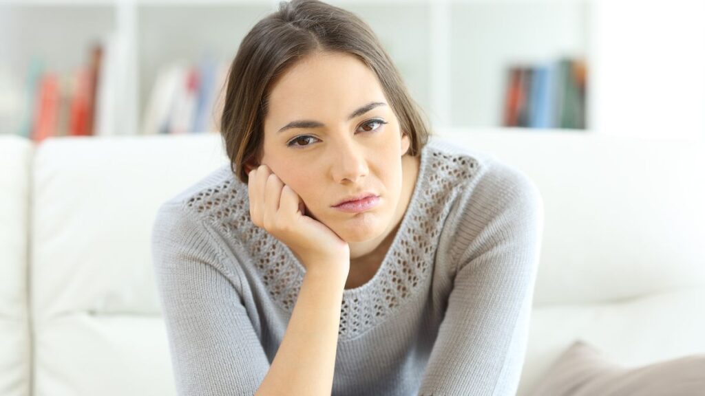 Woman wearing a grey sweater looking depressed