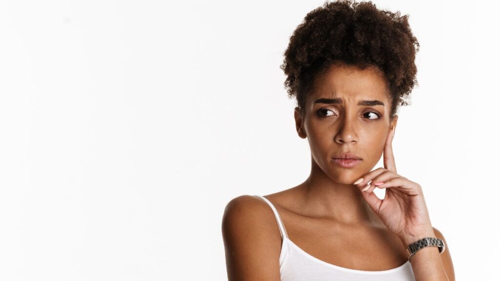 woman with hand on chin looking annoyed and upset