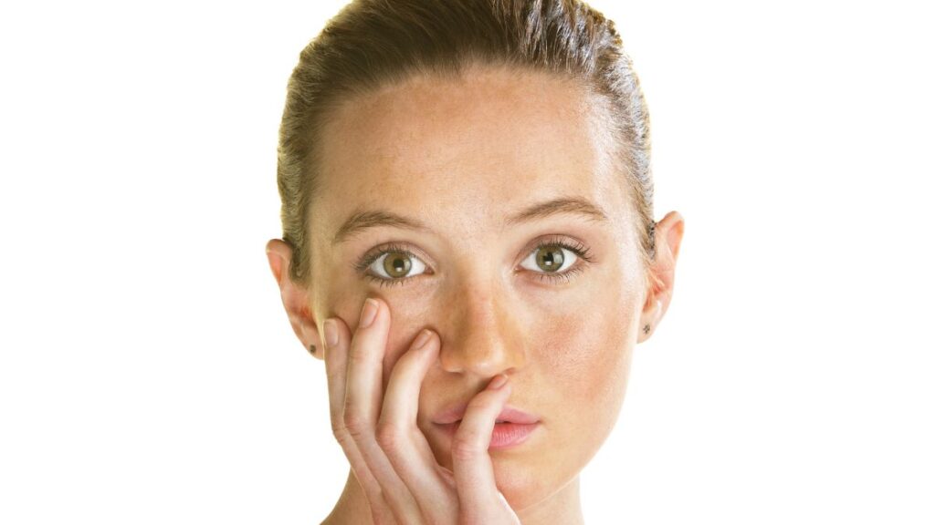 woman with her hand on her face and a blank stare