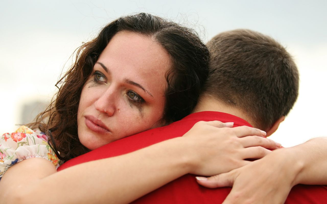 woman with makeup going down her face from crying as she hugs a man