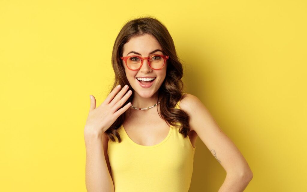 woman - yellow shirt and background, fanning herself happy