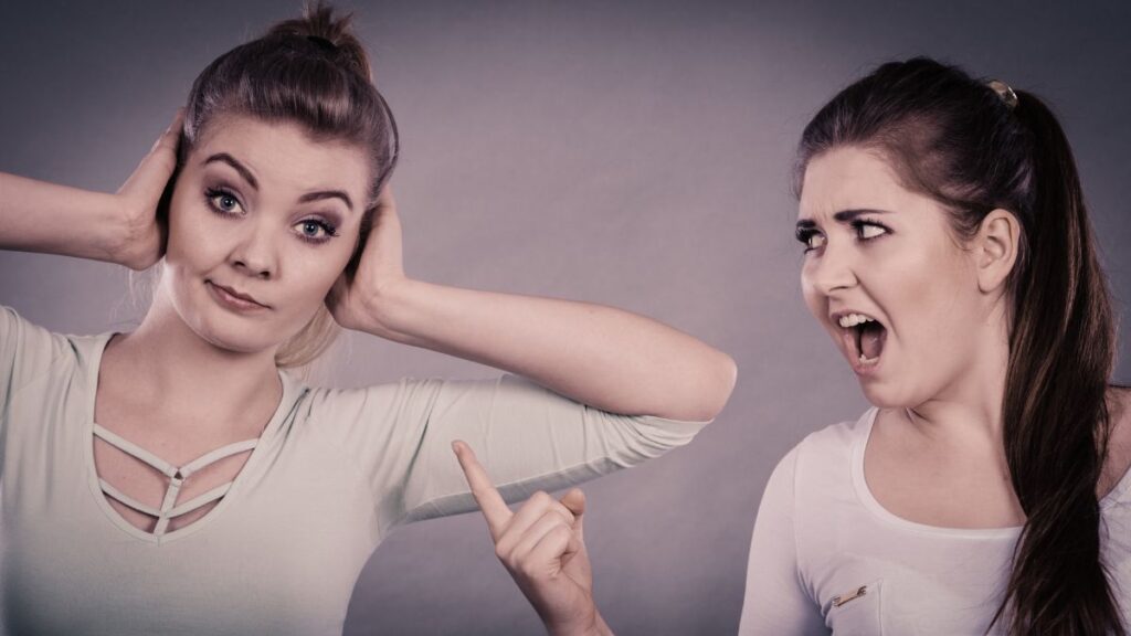 women fighting one pointing and yelling one with hands over ears